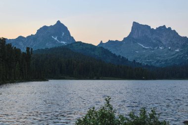 Dağlarda iki kayalık tepe ve alacakaranlıkta Svetloye Gölü. Ergaki doğa parkı, Sibirya, Krasnoyarsk bölgesi, Rusya. Yaz manzarası. Peak Ptitsa ve Zvezdnyy