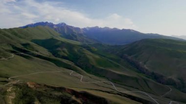 Dağlarda dolambaçlı bir yol. Yüksek kalite 4K Aeral drone yaz videosu. Kırgızistan 'daki rotalar 
