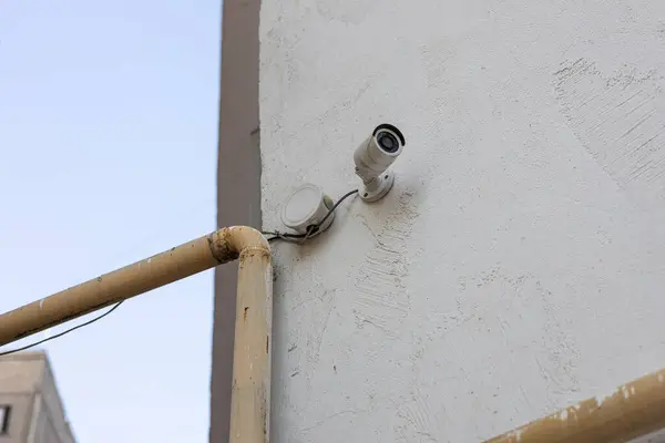 Street surveillance camera in the courtyard of a house mounted on the wall. Ensuring security with Video Recording.