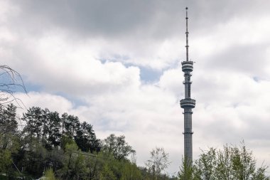 Bulutlu bir gökyüzünün arka planına karşı TV kulesi. Koktobe Televizyonu ve Kazakistan 'daki radyo yayın kulesi. Şehirler eğlencesi, park