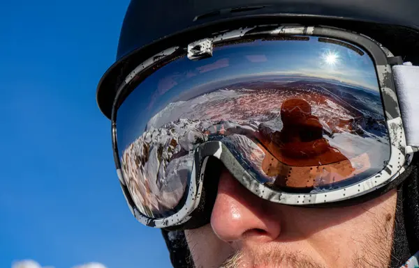 Kayak gözlüklerindeki yansıma: Kayak yapmak için karlı dağ yamaçları. Kayakçı ya da snowboardcu ekipmanı: kask, maske, gözlük. Hafta sonu aktif spor tatili, kış güneşli bir günde snowboard tatili.