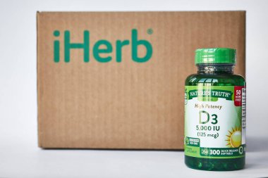 Doğa 'nın Doğruluk Şirketi, Yeşil kavanoz Yüksek Potansiyel Vitamin D3, Hızlı Serbest Bırakma Softgelleri. Kahverengi karton kutu, gri arka plan, kopyalama alanı. İnternetten alışveriş, iHerb mağazası. Bishkek, Kırgızistan - 8 Aralık 2023.