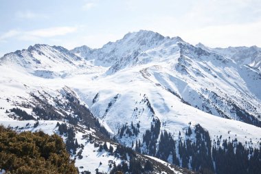 Karakol kayak merkezi. Kırgızistan 'ı ziyaret eden turistler için popüler tatil beldesi. Karla kaplı yüksek dağların tepesinden panoramik manzara. Kış doğal manzarası, dağ sırası.. 