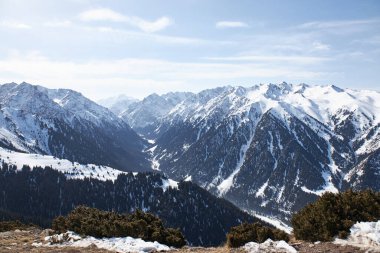 Karla kaplı yüksek dağların tepesinden panoramik manzara. Kış doğal manzarası, dağ sırası. Karakol Gorge, Kırgızistan 'da kayak merkezi.. 