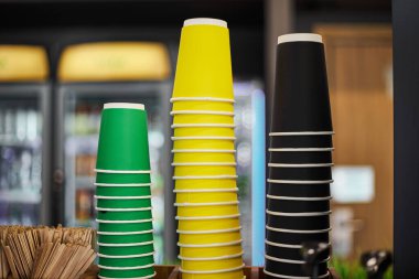 Boş üç deste renkli kağıt bardak, yeşil sarı bardak sıcak içecekler için farklı boyutlarda kahve, götürmek için çay. Kafe, dükkan, kafe işleri için maket. Alan arkaplan içeceğini kopyala 