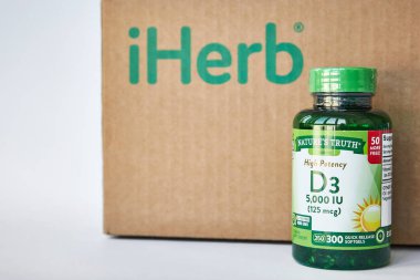 iHerb mağazası, Doğa Doğruluk Şirketi, Yeşil kavanoz Yüksek Potansiyel Vitamin D3, Hızlı Serbest Bırakma Softgelleri. Kahverengi karton kutu, gri arka plan, kopyalama alanı. İnternetten alışveriş. Bishkek, Kırgızistan - 8 Aralık 2023.