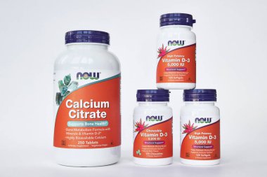 iHerb online mağazasından kavanozlar dolusu kalsiyum sitrat ve D-3 vitamini, Now Foods Company. Sağlıklı gıda, vitamin ve mineraller seti. Gri arka plan. Bishkek, Kırgızistan - 8 Aralık 2023. 