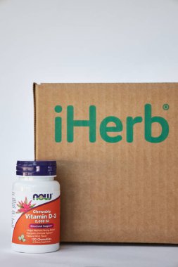  iHerb Brown karton kutusunun yanındaki D3 vitamini şirketi. Online mağazadan besin takviyeleri almak, paketleri açmak. Sağlık hizmeti, ilaç. Bishkek, Kırgızistan - 8 Aralık 2023