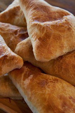 Üçgen şeklinde puf böreği. Lezzetli Asya yemekleri, geleneksel doğu mutfağı Tacikistan, Özbekistan, Kırgızistan, Kazakistan. Taze pişmiş yiyecekler: etli ve patatesli samsa yakın plan, yan görüş. 