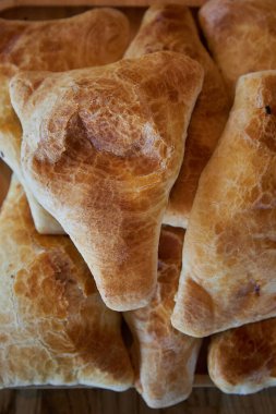 Lezzetli Asya yemekleri, geleneksel doğu mutfağı Tacikistan, Özbekistan, Kırgızistan, Kazakistan. Üçgen şeklinde puf böreği. Taze pişmiş yiyecekler: etli samsa veya patatesli yakın plan, üst manzara. 