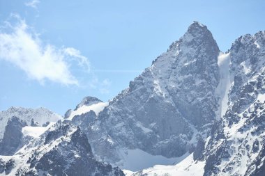 İskoçya 'da yürüyüş. Karlı dağ manzarası, mavi gökyüzü, kayalık uçurum. Vahşi doğa. Yükseklik dağları tırmanıyor, karla kaplı zirveler. Kırgızistan doğa keşfi