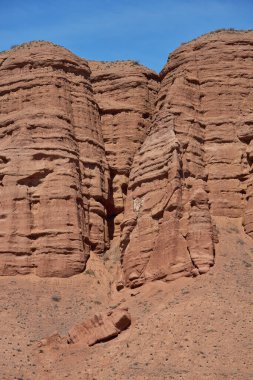 Kum taşı üzerinde yüz. Pareidolia, yüze benziyor. Pareidolik yanılsama, cansız nesnelerin içinde yüzler görmek. Rocky sütunları Konorchek kanyonu, aeolian yatakları, toprak erozyonu sonucu sarp kayalıklar.