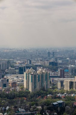 View of Almaty city, Republic of Kazakhstan, Central Asia. Cityscape at springtime, high-rise and low-rise buildings, residential buildings, offices and business centers. Haze over the town. ecology clipart