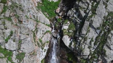 Kırgızistan 'daki Ala-Archa Ulusal Parkı' nda şelale var. Şelalenin üzerinden uçarken, İHA 'nın 4K görüntülerinden bir hava görüntüsü. Su sıçrayan hava akımı. Yaz manzarası doğal manzara