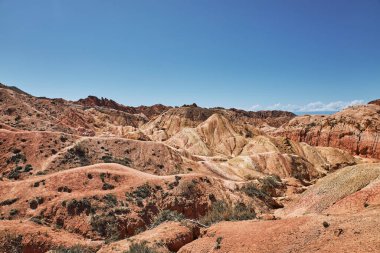 Kırgızistan 'ın Issyk-Kul Gölü' nün güney kıyısındaki Picturesque Skazka Kanyonu. Seyahat güzergahı, Kirgiziya 'nın işareti. Renkli kayalar ve tepelerle dolu yaz masalı kanyonu. Doğal park manzarası