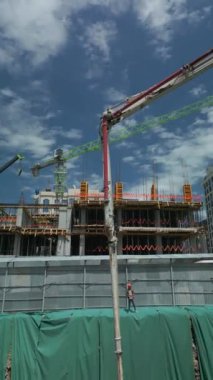 İşçiler beton pompa ile binanın tabanına çimento dökerler. İnşaat alanı, çukur. Beton mikser ile bölgeye teslim edilir. Hava aracı 4k dikey görüntü. 