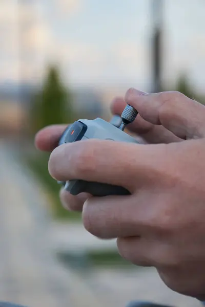 stock image Male hands hold a drone control panel, close-up. Management by quadcopter flight and videotaping from above. Day time outdoor. Videography work, hobby