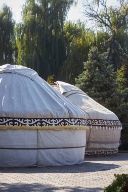 Türk ve Moğol göçebeler arasında keçeli kalemle kaplanmış taşınabilir çerçeve konutları. Bishkek şehir parkında iki çadır yemyeşil ağaçlarla çevrili. Yurt - Kırgızlar 'ın tarihi evleri