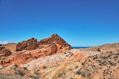 Kırgızistan 'ın Issyk-Kul Gölü' nün güney kıyısındaki Picturesque Skazka Kanyonu. Seyahat güzergahı, Kirgiziya 'nın işareti. Renkli kayalar ve tepelerle dolu yaz masalı kanyonu. Doğal park manzarası