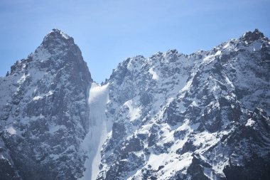 Karlı dağ zirveleri, kaya. Uçsuz bucaksız arazi, dik yamaçlar. Ala-Archa Ulusal Parkı, Kırgızistan.