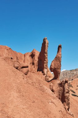 bizarre forms of sandstone after weathering and soil erosion. red rugged sandstone. eroded sand rock. dry climate, canyon area. amazing drawings of nature. Skazka canyon, fairytale. Kyrgyzstan clipart