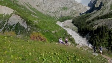 Turistler Ala-Archa Ulusal Parkı 'nda yürüyüş yaparken dinlenirler. Seyahat güzergahı. Hava aracı görüntüleri. Popüler dinlenme yeri. Kırgızistan - 6 Temmuz 2023