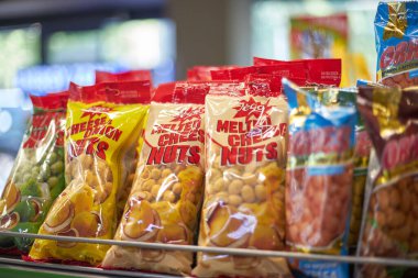 Bira aperatifleri, jöleli fıstıklar erimiş peynir ve soğan tadı. Süpermarketteki bir rafta renkli paketlerde fındıklar. Bishkek, Kırgızistan - 26 Mayıs 2023