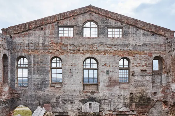 1912 'de yıkılmış tuğla bina terk edilmiş. Eski sanayi tesislerinin pencereleri olan duvar, ağaçlarla kaplı Cam Fabrikası alanı, Krasnoyarsk, Hafıza 13 Bortsov. 