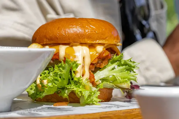 Bol soslu sulu hamburger, peynir ve marul. Sağlıklı değil ama çok lezzetli yüksek kalorili yiyecekler. Sokak yemeği, sahte fotoğraf değil.