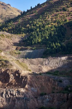 Dağda eski bir maden ocağı. Açık maden ocağı, maden arazisi. Tarihi seyahat yeri Ak-Tyuz, Kırgızistan. Terk edilmiş Kırgız madencilik ve metalürji fabrikası. Kurşun madenciliği, mevduat