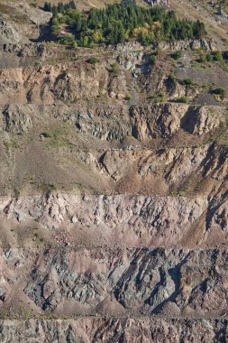 Old open mining pit in mountain. Open-pit quarry, mine landscape. Historical travel destination place Ak-Tyuz, Kyrgyzstan. Abandoned Kyrgyz mining and metallurgical plant. lead mining, deposit