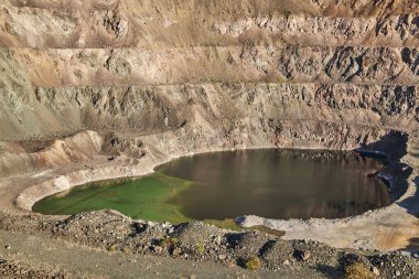 Dağda eski bir maden ocağı. Açık maden ocağı, maden arazisi, gölet. Tarihi seyahat yeri Ak-Tyuz, Kırgızistan. Terk edilmiş Kırgız madencilik ve metalürji fabrikası. Kurşun madenciliği, mevduat
