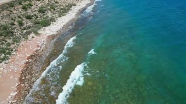 Issyk-Kul Gölü 'nün güney kıyısındaki vahşi bir sahilde dalgalar. Kırgızistan 'a seyahat. Turkuaz su. Hava aracı görüntüleri.