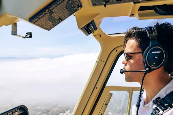 Pilot bulutların üzerinde uçan helikopteri kontrol ediyor, içerideki uçak kabinini görüyor. Cape Town, Güney Afrika - 23 OCT 2023