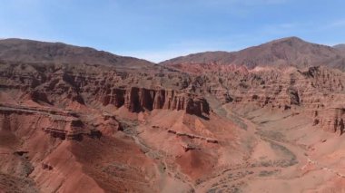 Erozyona maruz kalan sarp kayalıklar, Kırgızistan, Orta Asya 'nın tabiat simgesi. Kaya oluşumu, doğal manzara, yürüyüş alanı, kumtaşı kırmızı kayalar. Seyahat güzergahı Konorchek Kanyonu, Hava 4k