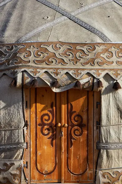Ulusal desenli ahşap kapı, Kırgız yurduna giriş, kapatın. Geleneksel Göçebe binası