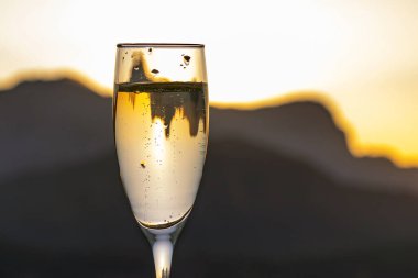 Gün batımında bir bardak köpüklü şarap