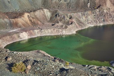Dağda eski bir maden ocağı. Açık maden ocağı, maden arazisi, gölet. Tarihi seyahat yeri Ak-Tyuz, Kırgızistan. Terk edilmiş Kırgız madencilik ve metalürji fabrikası. Kurşun madenciliği, mevduat