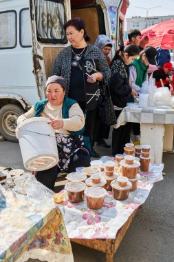 Sokak satıcıları plastik kaplarda, Nowruz kutlamalarında şenlikli çanak satıyorlar. Bishkek, Kırgızistan - 21 MAR 2023