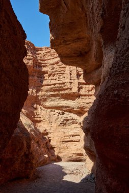 Kanyonun dibinde, kırmızı kumtaşı kayalarıyla çevrili yürüyüş izleri..