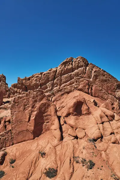 Hava durumu ve toprak erozyonundan sonra kumtaşının garip şekilleri. Kırmızı, engebeli kumtaşı. aşınmış kum kayası. Kuru iklim, kanyon bölgesi. Doğanın inanılmaz çizimleri. Skazka Kanyonu, peri masalı. Kırgızistan