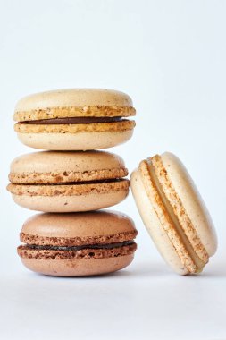 Dört tane kahverengi Fransız makarnası, farklı aromalı kekler, kahve ve creme brulee aromalı. ev yapımı tatlı piramidi, badem kurabiyesi yan görünümü, metin için boşluk kopyalama, yakın çekim