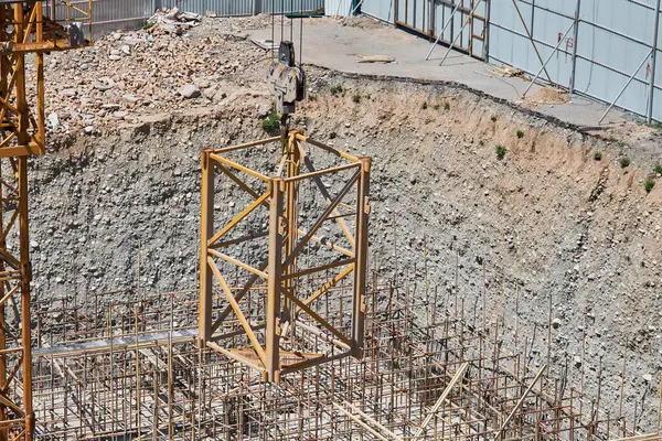 İnşaat vinci, kancadaki ek vinç bölümünü kaldırarak yüksekliği arttırır. İnşaat alanı, temel çukuru