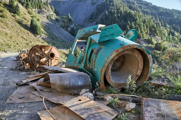 Büyük ve paslı bir endüstriyel hurda yığını, atıklar ve atıklarla üst üste yığılmış. Yakından bakınca, paslanmış, bakımsız endüstriyel hurda yığını açık hava ortamında görünüyor.