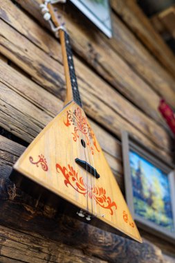 Ahşap duvarda asılı etnik müzik enstrümanı Balalaika. seçici odak.