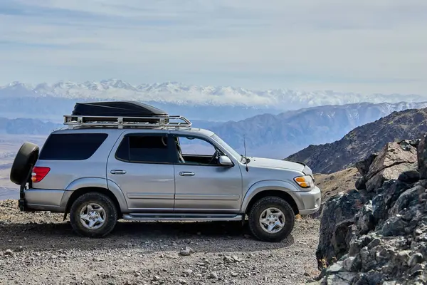 Dağlarda tavan rafı olan gri renkli Toyota Sequoia. Kırgızistan - 11 Nisan 2024.