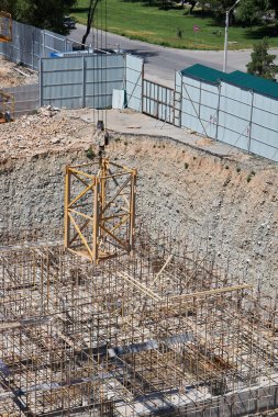 İnşaat vinci, kancadaki ek vinç bölümünü kaldırarak yüksekliği arttırır. İnşaat alanı, temel çukuru.