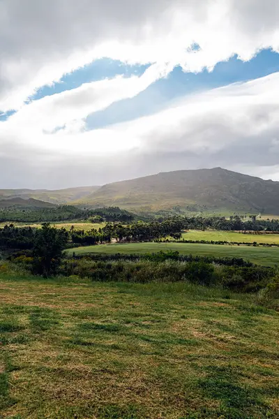 Kırsal doğa, tarımsal alanlar. Bulutların arasından güneş ışığı.