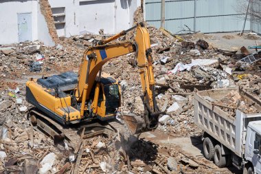 Kazıcı evin enkazının üzerinde duruyor. Sökülme işlemi, eski binanın yıkılması, harap olmuş konutların tahrip edilmesi.