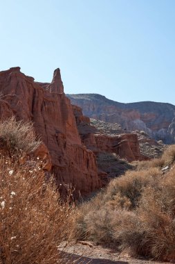 Çöl kızıl kayalıkları. Kızıl kaya oluşumları, açık mavi gökyüzü olan kanyon manzarası..